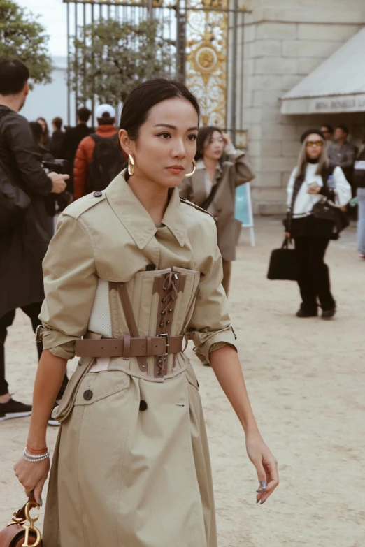 a model wearing a trench and belt on the street