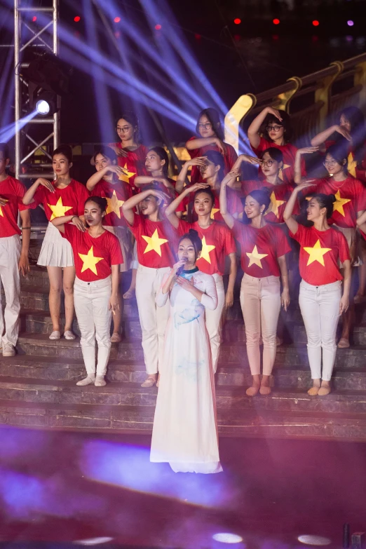 a woman standing next to a group of people holding stars