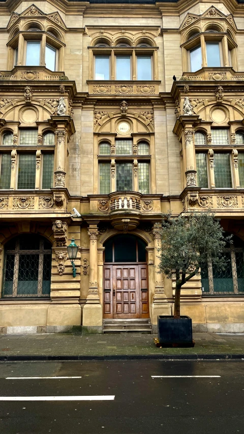 the front entrance to an older building with a tree in the foreground