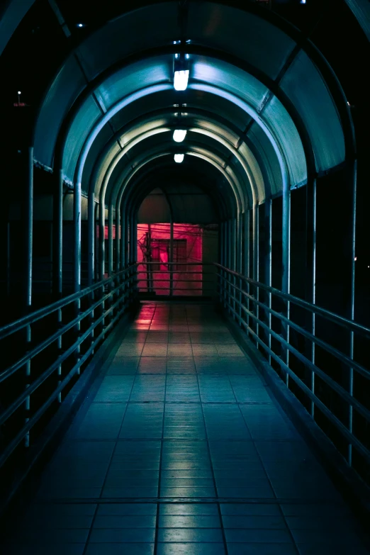 a walkway that is lit with lights and surrounded by bars