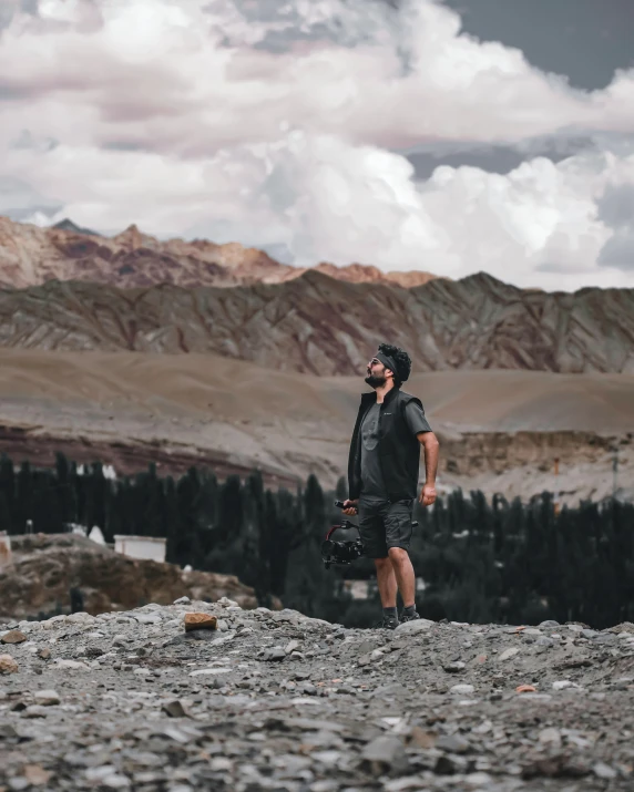 a man holding a suitcase on top of a hill