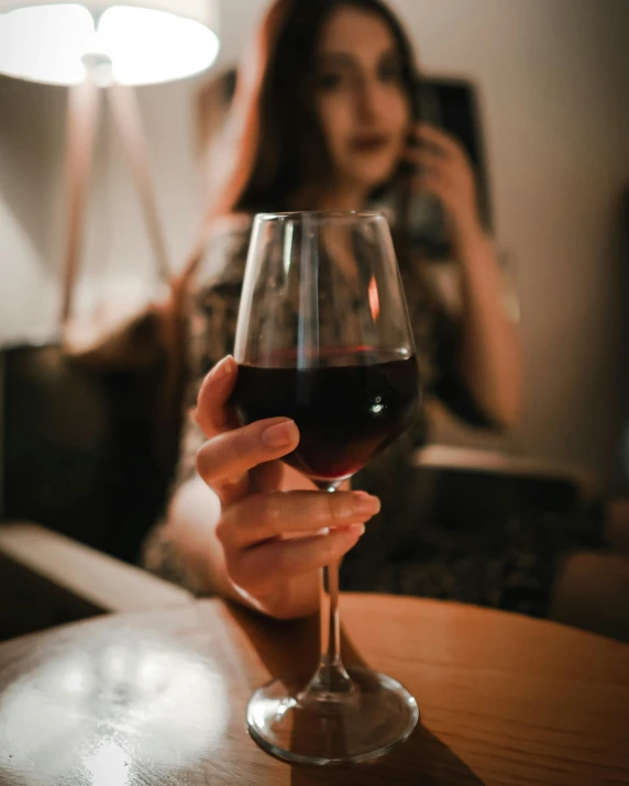 a woman holding a glass of red wine