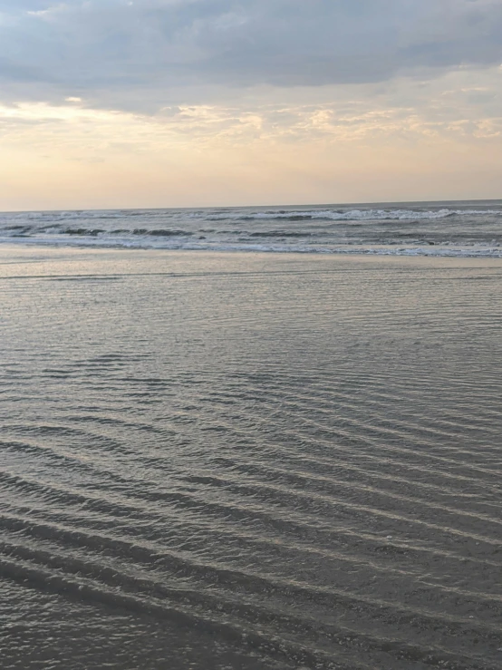 a surfer is riding a small boat near the ocean