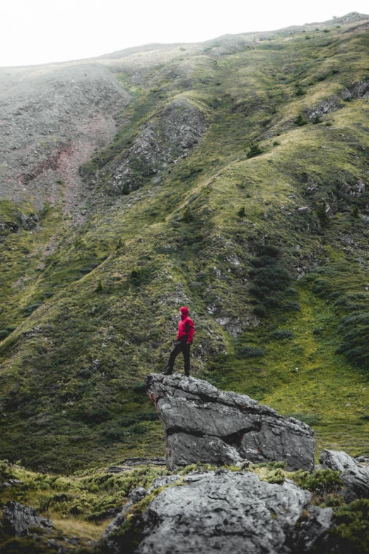 man with hiking gear standing on a rock outcropping