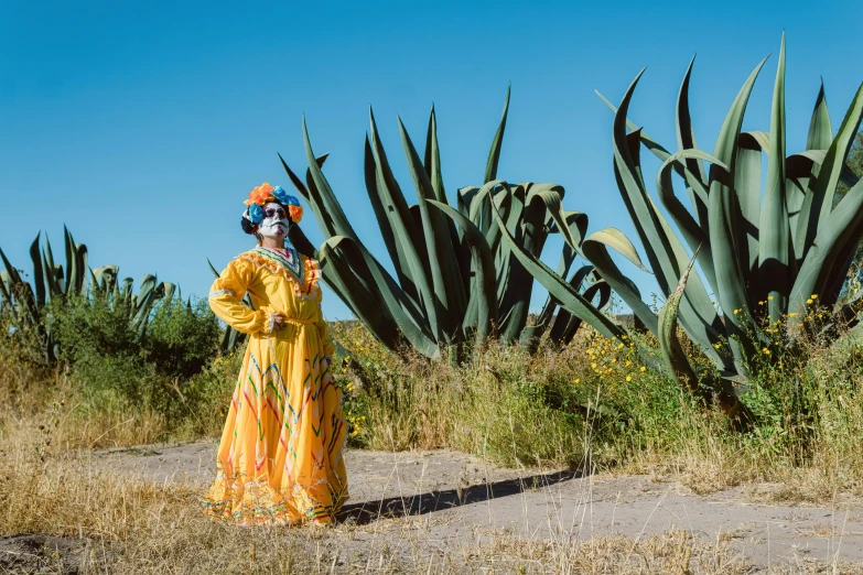 a woman in a yellow dress in the middle of a field