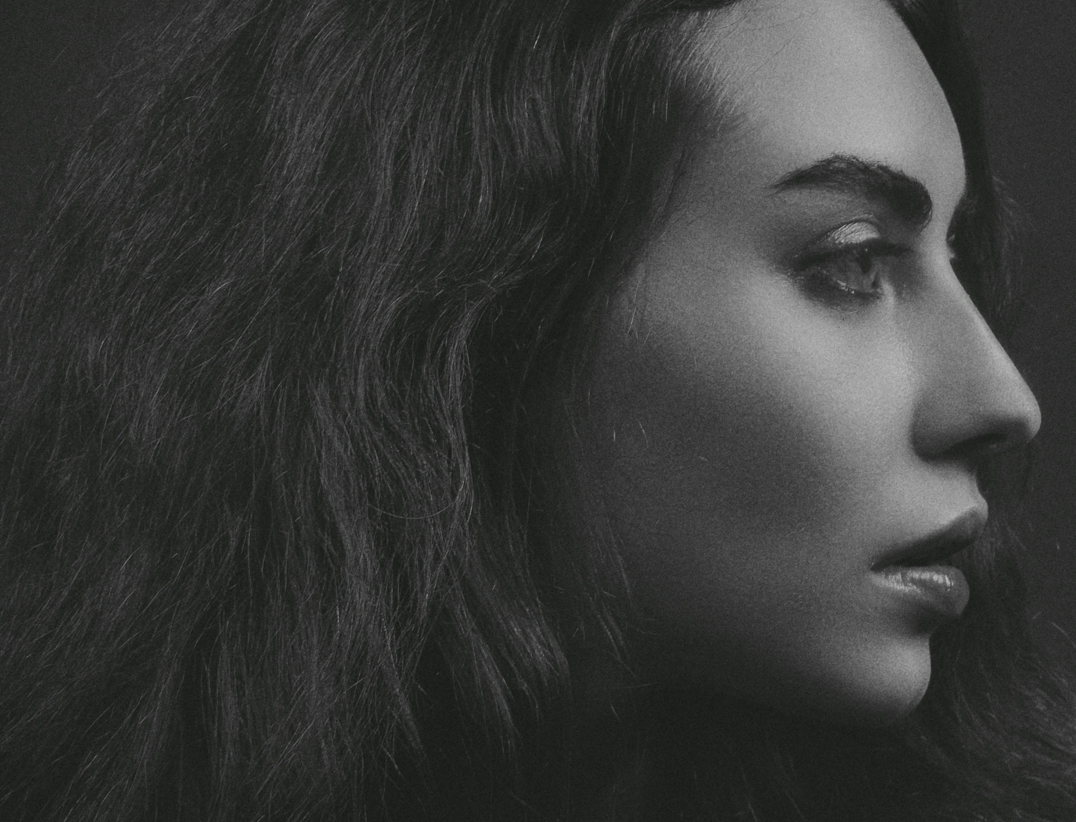 a woman with long hair looking away from the camera