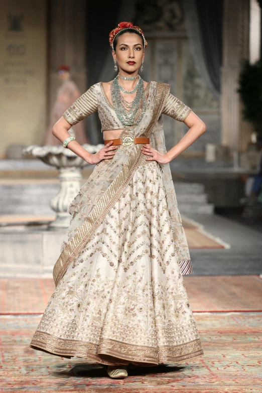 a model in white clothing standing on a runway