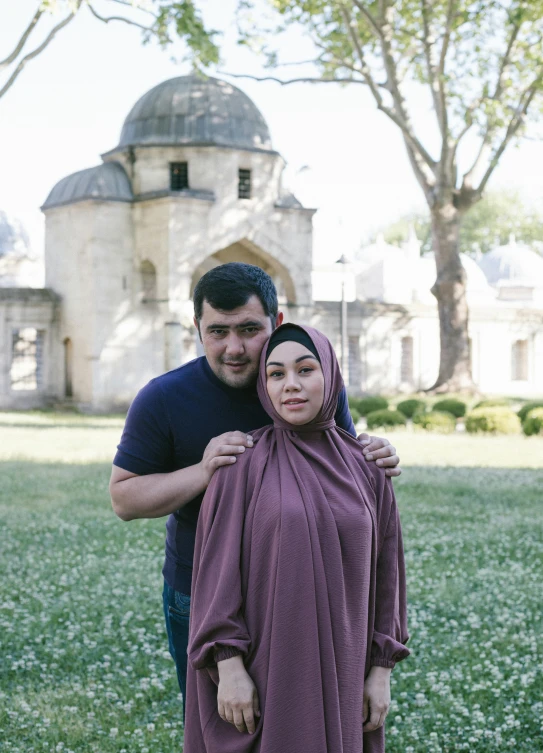 a man and woman are posing for a po in front of an old building