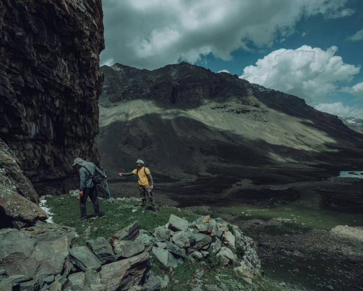 two hikers are on the top of a steep mountain