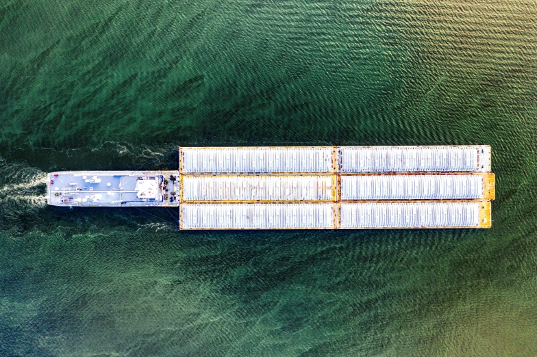 large barge sails on green water in the middle of ocean