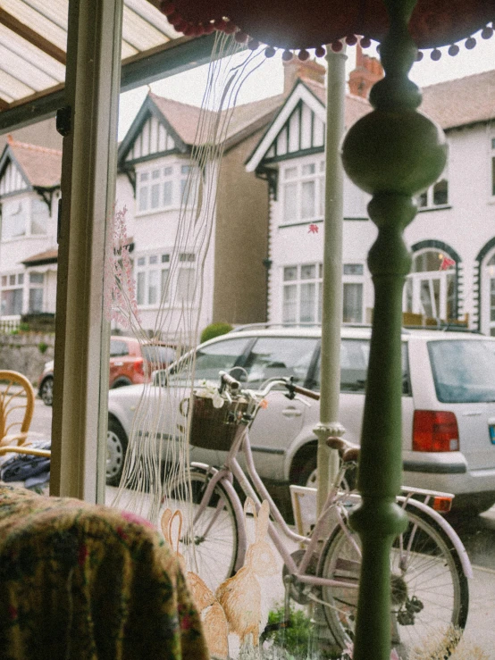 a bicycle parked next to a pole in front of a window