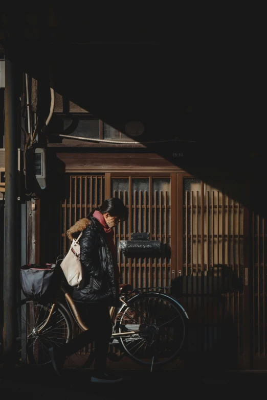 a woman in black jacket next to bicycle with baskets