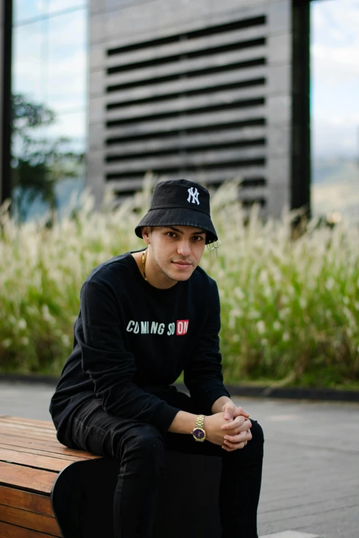 the boy is sitting on a bench with his hat on