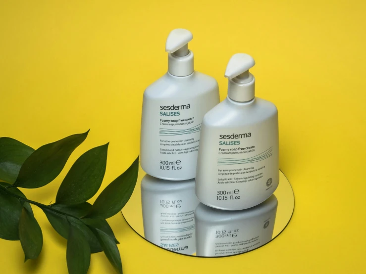 three bottles sitting on top of a tray next to a plant