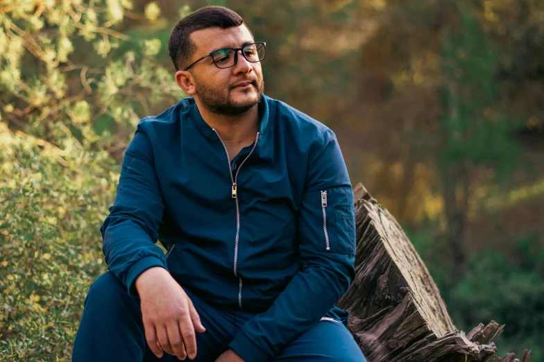 man sitting on a log and looking at the camera