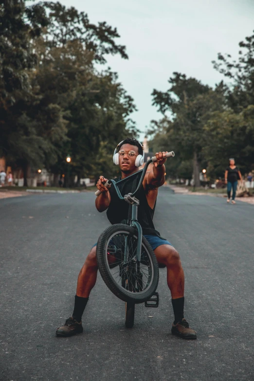 a man is holding a bicycle in the middle of a street