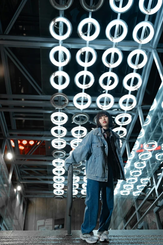 a man stands in front of a sculpture that is decorated with lights