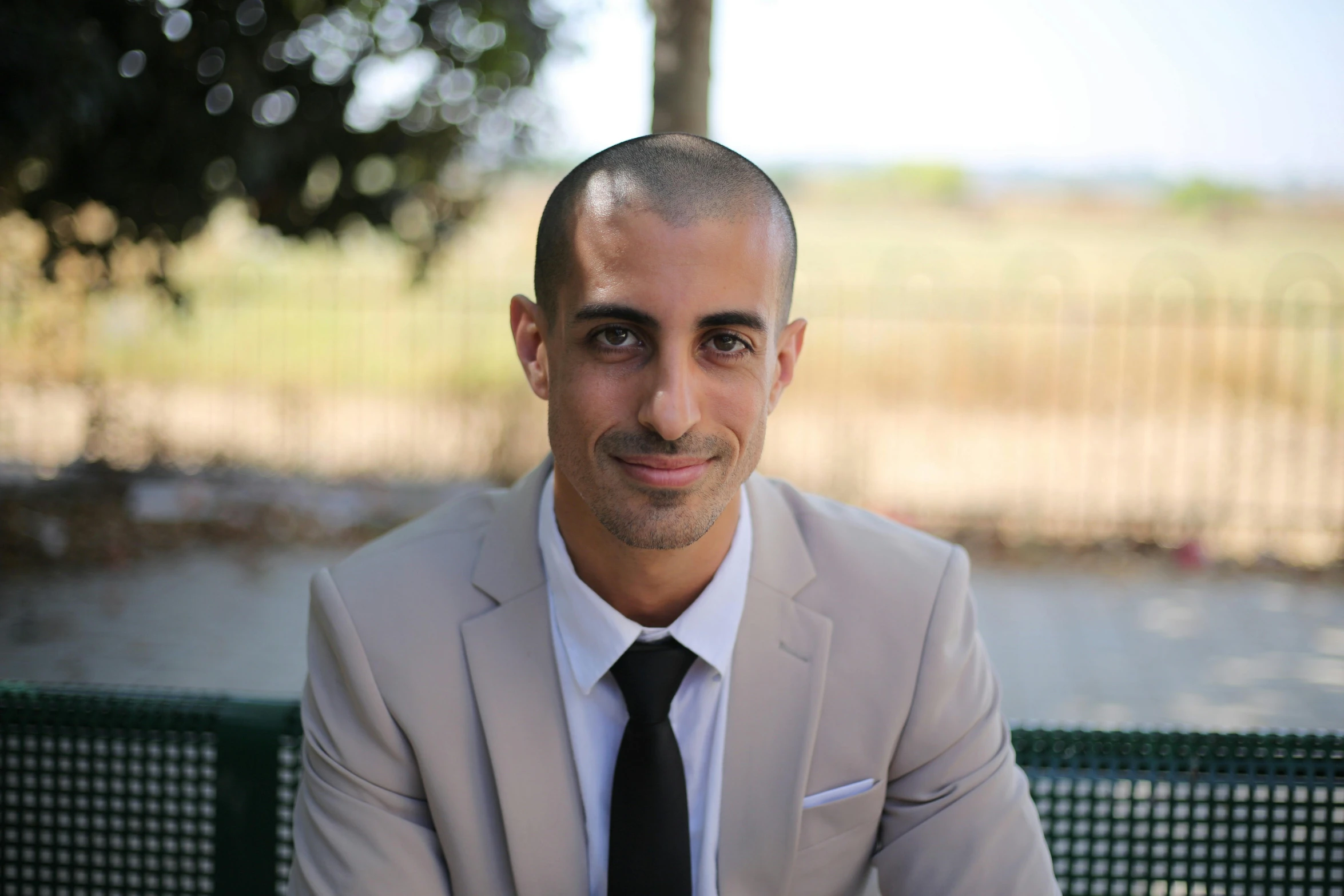 an image of man sitting outdoors in a suit