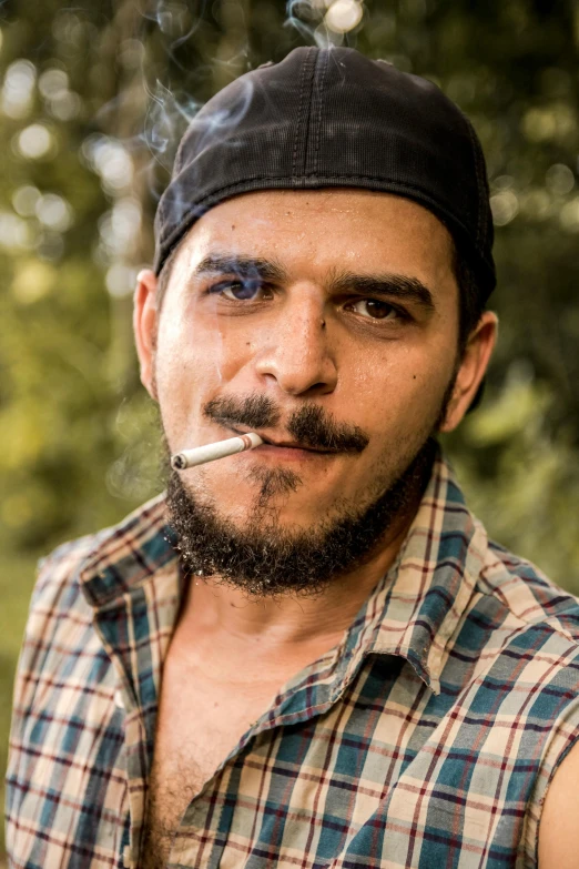 a man with a beard smoking a cigarette