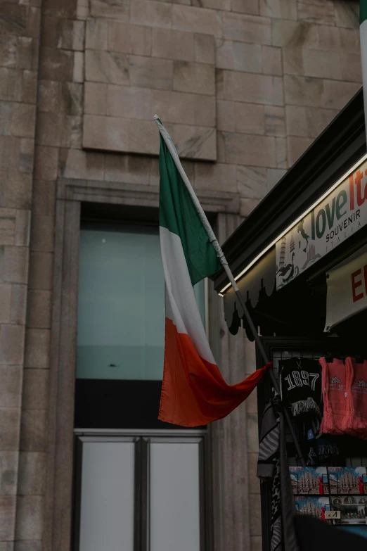 a flag hanging outside a building on the side of the street