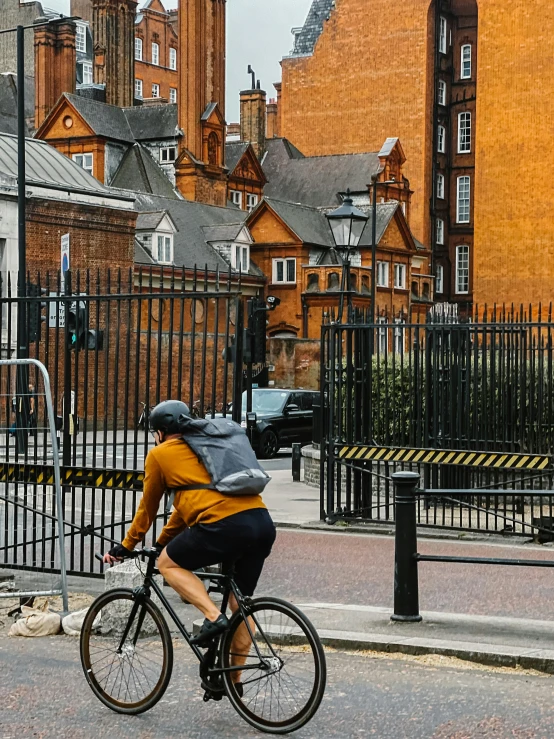 a man on a bicycle is approaching an iron gate