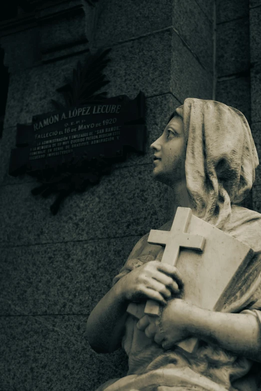 the statue is holding a book while looking up at it