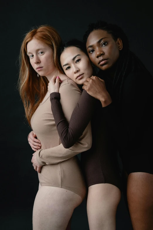 three girls standing in front of a black background