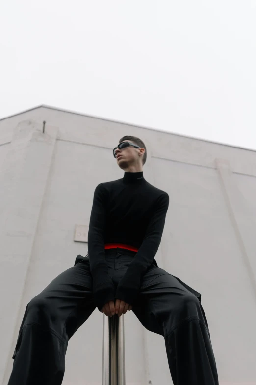 a person sitting on a pole posing for a picture