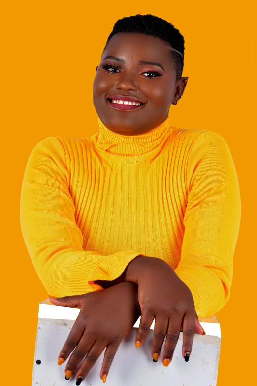 a woman posing for a studio picture in an orange shirt