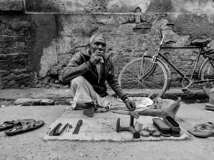 black and white pograph of a man on the ground near a bike