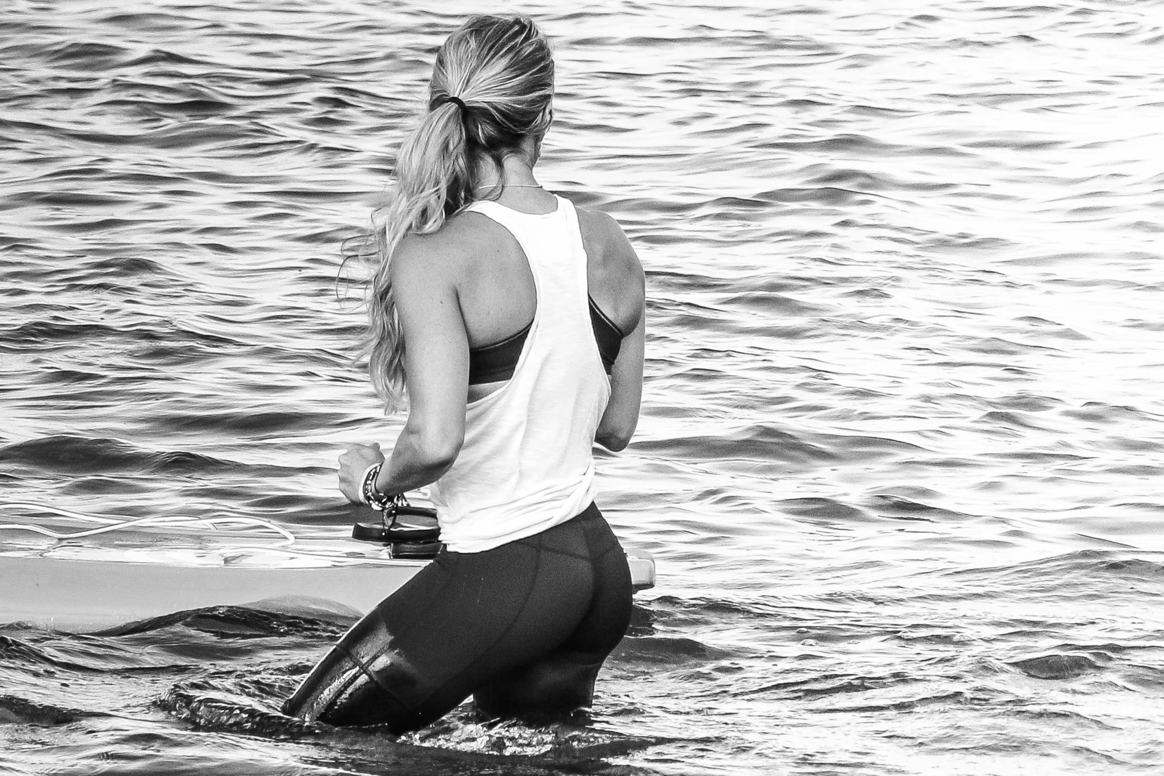 a woman with a camera walking into the water