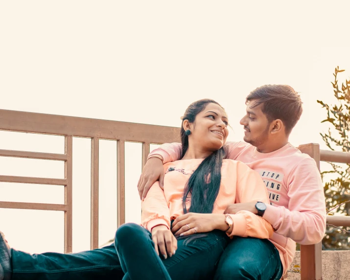 man in pink shirt with arm around a woman's waist