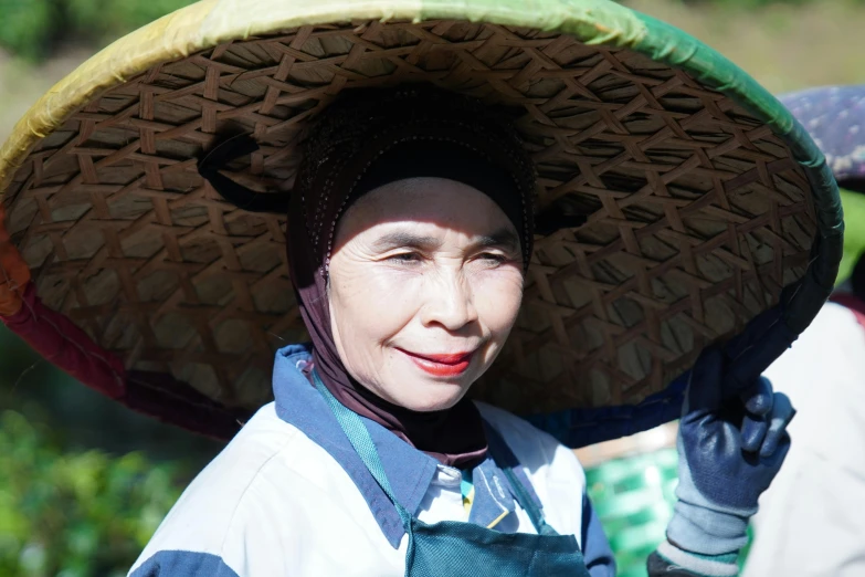 a woman is smiling wearing a large sombrero