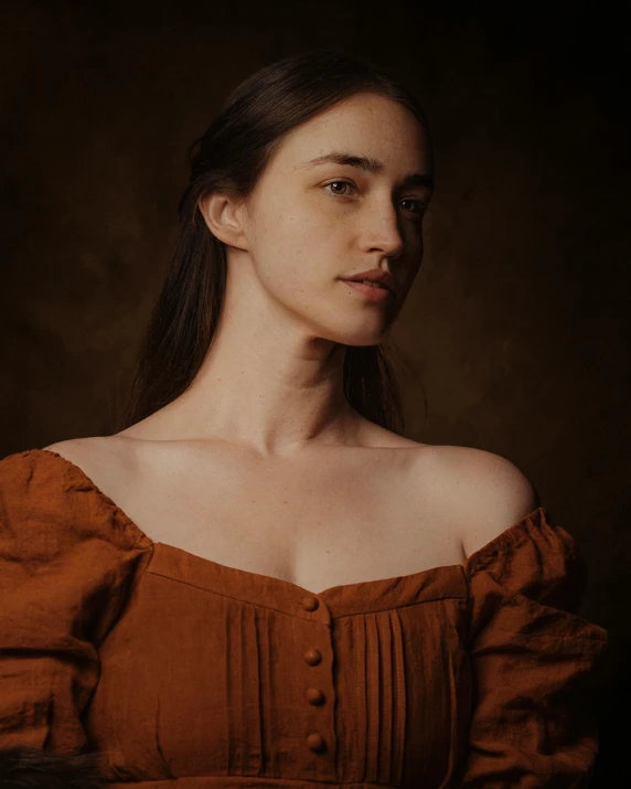 the woman is in an off - shoulder dress against a dark background