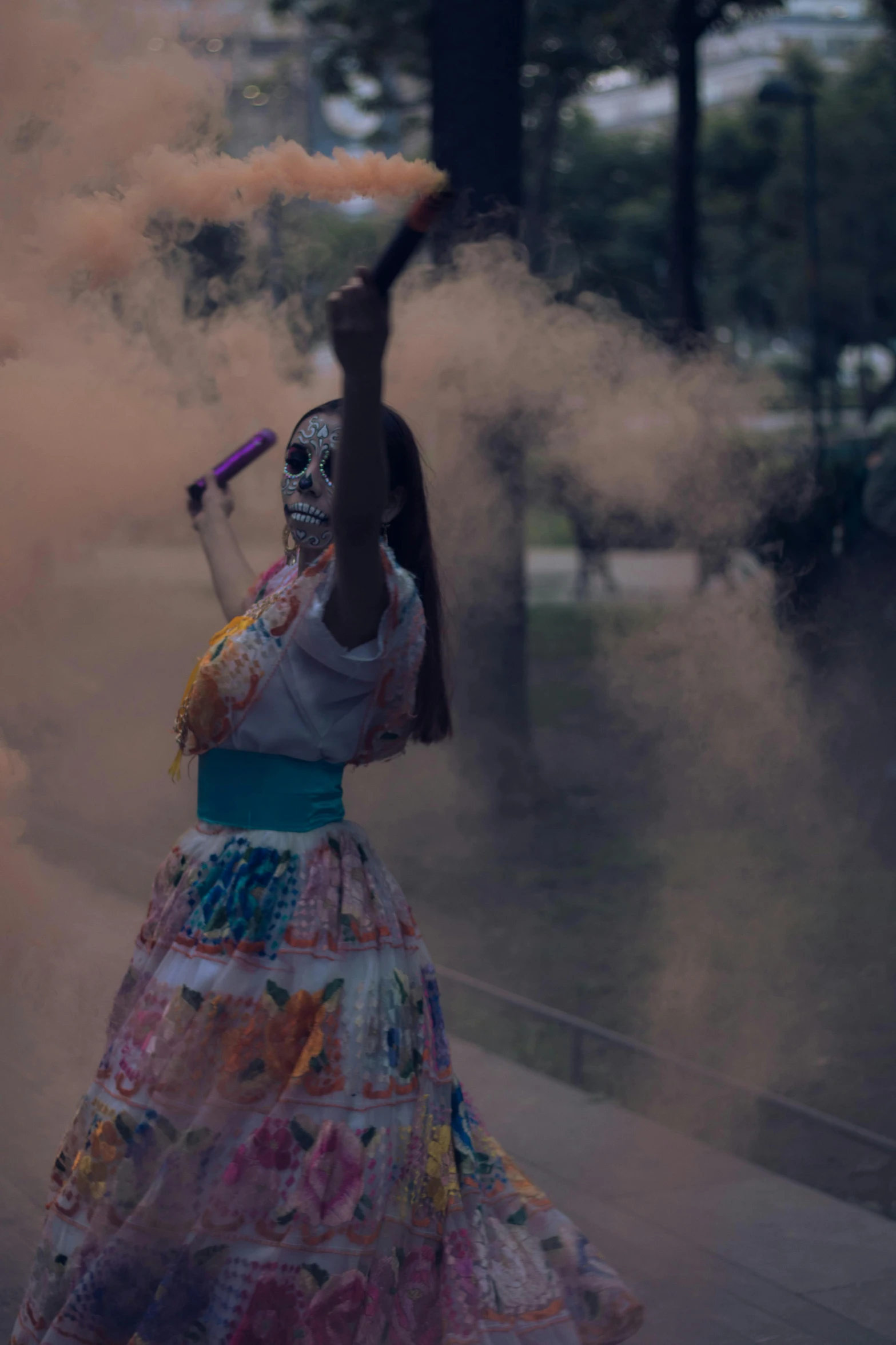 a woman dressed up with a mask and a dress is holding an item