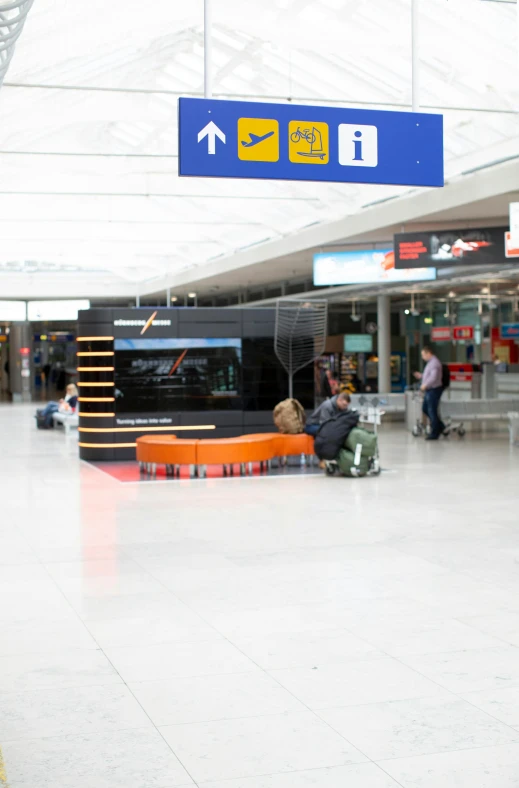 some people sitting by the baggage claim of a airport