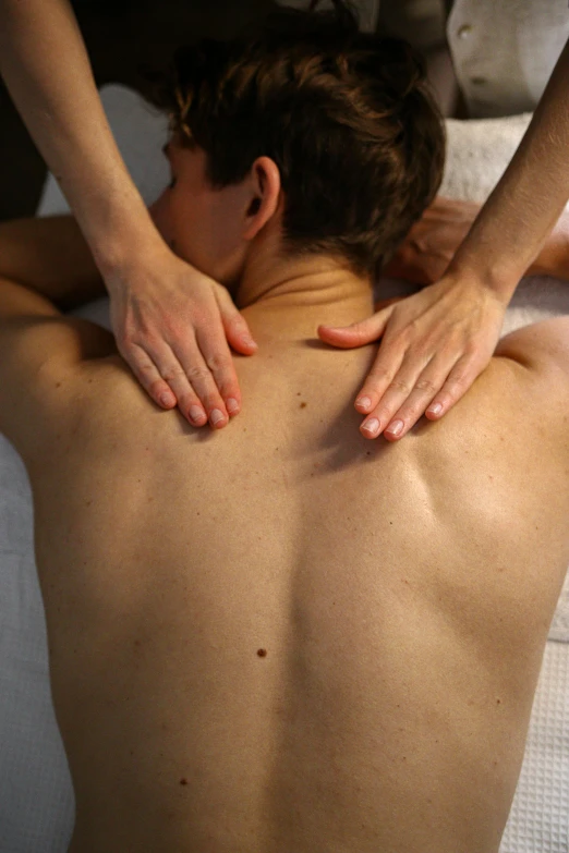 a woman receiving back massage on a bed