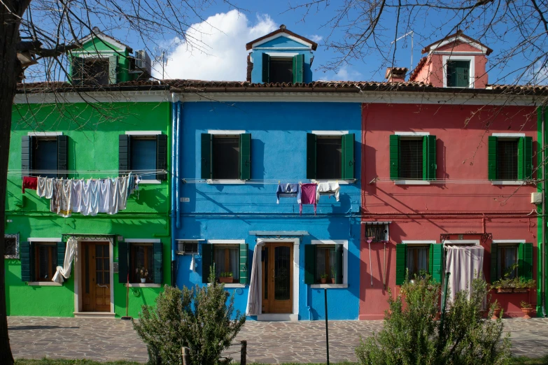 multiple colored buildings on a street corner that are painted in different colors