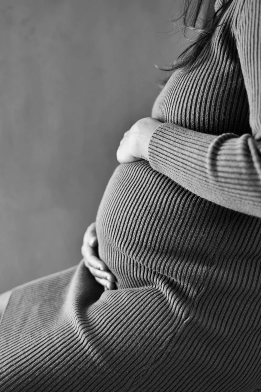 a pregnant woman has her stomach curled back