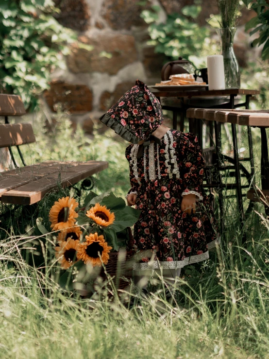 an old woman dressed in a sunflower print dress sitting on a bench