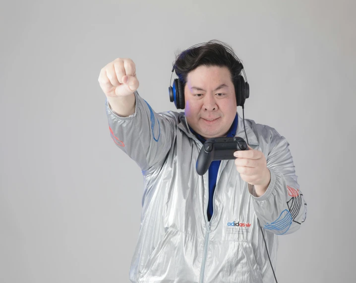 a man wearing headphones, holding up soing