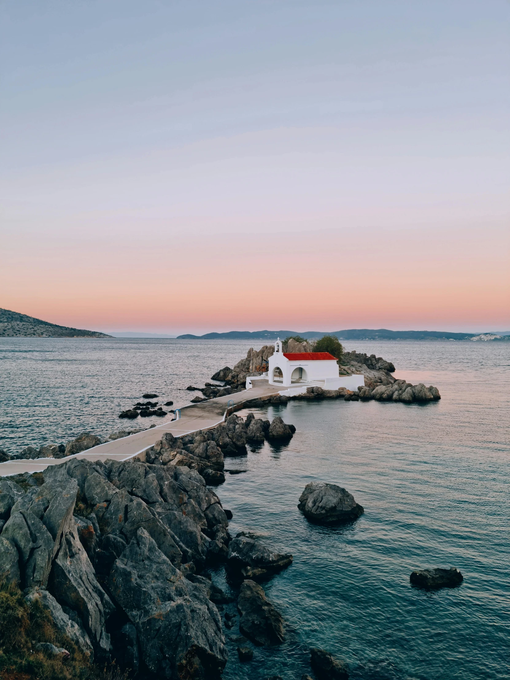 the lighthouse sits out over a rocky shore