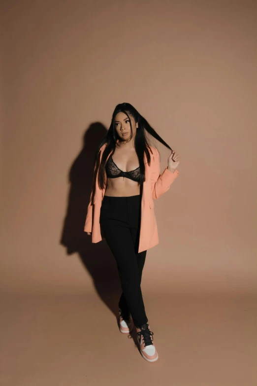 a woman wearing black and pink clothes standing in front of a light wall