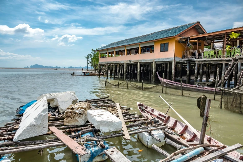 boats are docked near a very colorful house on the shore