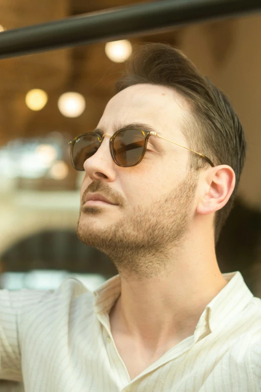 man in brown and beige sunglasses looking out window