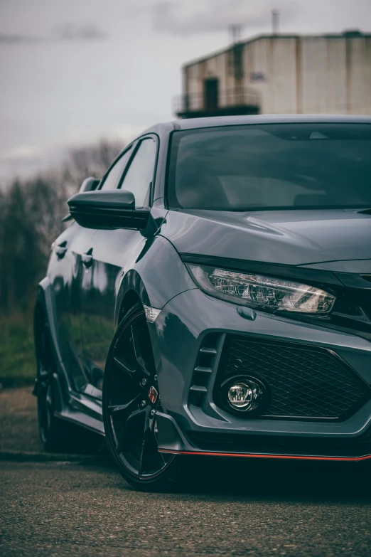 a black honda civic hatchback in front of a building