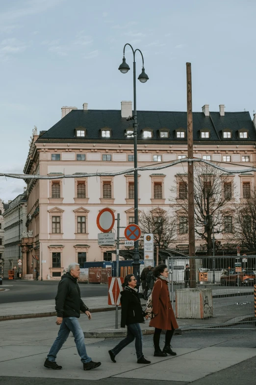 the men are walking on the city sidewalk