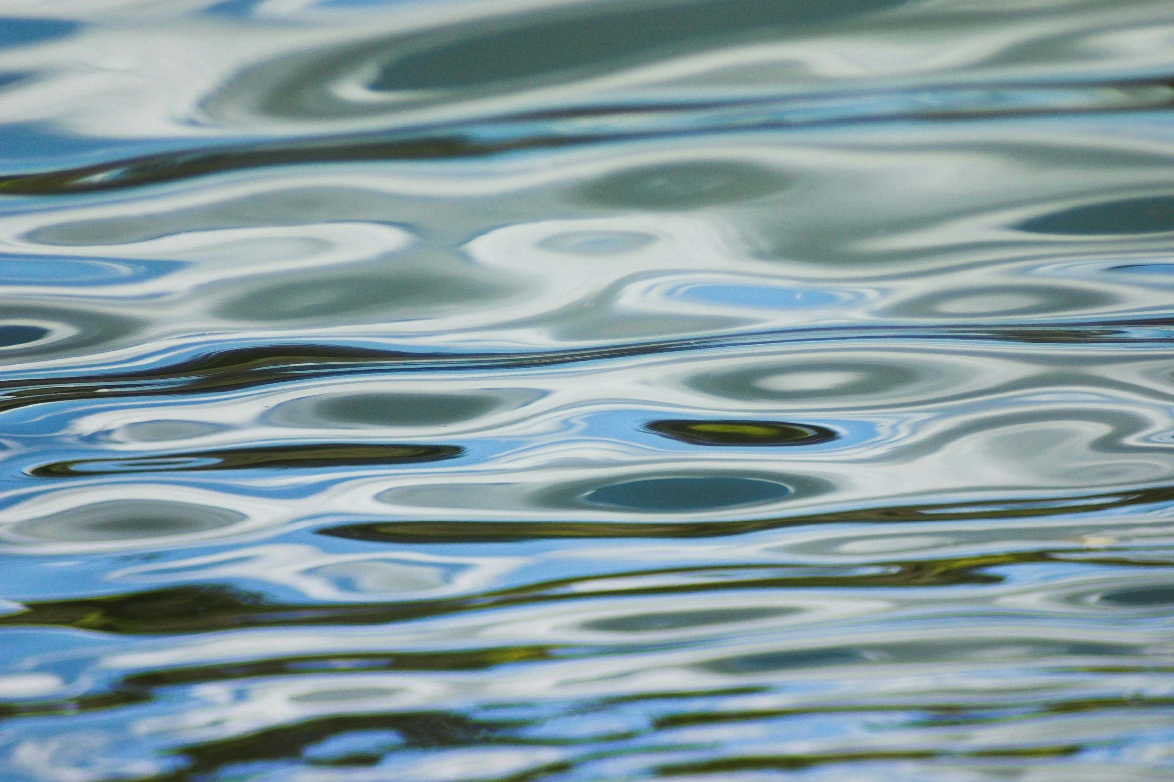 the water is reflecting the sky and some clouds