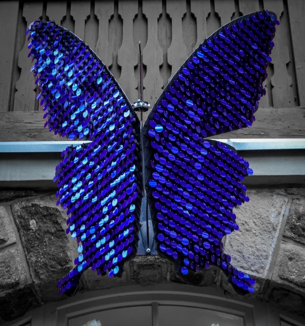 a large purple erfly perched on top of a building