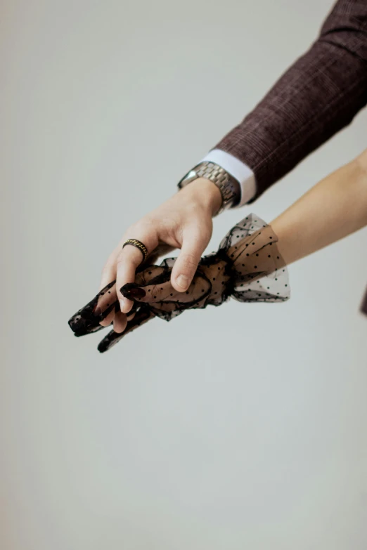 the hands of two people wearing matching dress with gloves